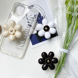 Floral expandable phone socket grip set with romantic clear case on white textured surface