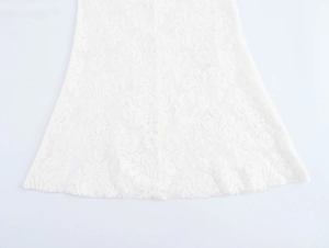 Detailansicht des weißen Spitzenkleid-Saums mit Stickerei und strukturierter Textur