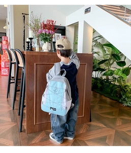 Kind met lichtblauwe en witte schoolrugzak voorzien van elastisch trekkoord