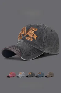 Detail of vintage washed cotton baseball cap with large M embroidery and leather brim accent