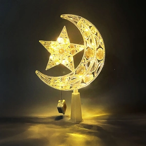 Close-up of warm yellow glowing star and moon decoration with beads and metal wire
