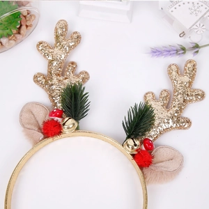 Detail of Christmas headband featuring gold sequin antlers with festive bells and berries