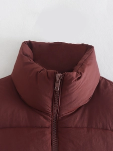 Detailed close-up of dark reddish-brown stand-up collar and quilted puffer vest fabric