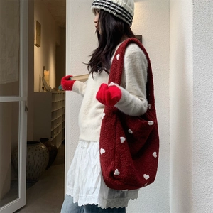 Detail of red plush tote bag with white heart pattern and soft faux fur texture