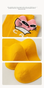 Detail of yellow cotton socks with cartoon cat embroidery and high-quality knit texture