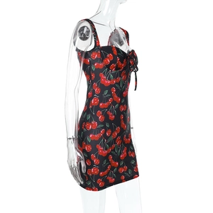 Detail view of cherry print mini dress with side bow ribbons on a 45-degree angle display