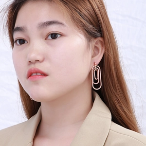 Detailed view of rose gold layered geometric spiral earrings worn by a model