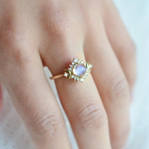 Gros plan d'une bague dorée bohème avec pierre de lune ronde et détails de croissant