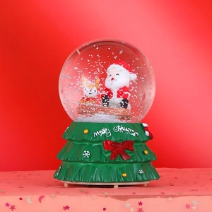 Detail of Christmas crystal ball with Santa and deer inside a festive snow globe