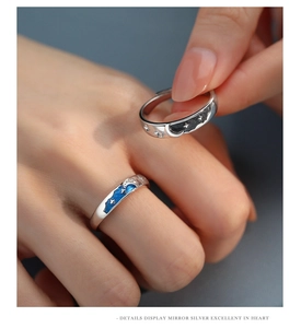 Macro shot of silver sun and moon couple rings with blue and black enamel details