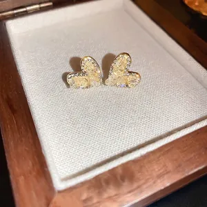 Elegant gold heart stud earrings with sparkling crystals displayed in a vintage jewelry box