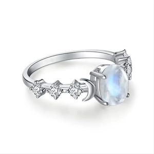 Macro shot of silver ring with oval moonstone and crescent moon star design details