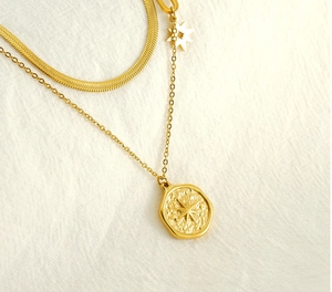 Detail of a vintage double-layer gold necklace featuring a star pendant and snake chain