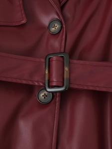 Détail du trench-coat en cuir bordeaux montrant la boucle de ceinture en écaille