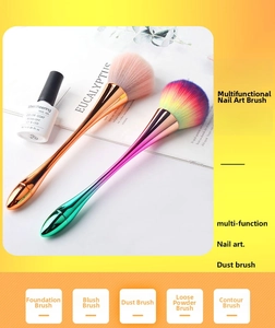 Detail of rose gold nail dust brush with soft pink bristles and rainbow finish handle