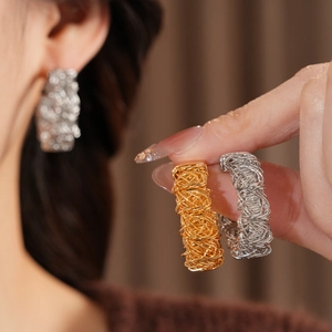 Detailed macro shot of textured gold and silver wire woven earrings for women