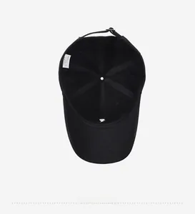 Detail view of the black cotton baseball cap interior structure and 100% cotton label