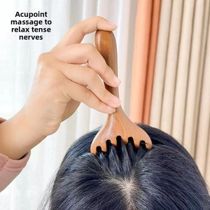 Detail view of wooden five-tooth scalp massager being used for meridian acupoint therapy
