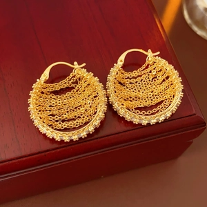 Detailed view of gold plated chain link earrings with clear zircon stones on a wooden box