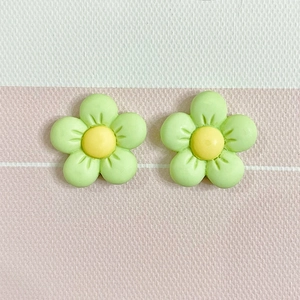 Macro view of matte light green resin five-petal flower DIY charms with yellow pistils