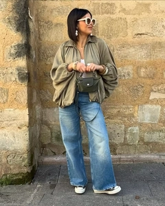 Style urbain avec veste aviateur vert olive et jean denim délavé bleu en extérieur