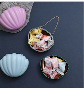 Macro shot of colorful shell-shaped metal candy boxes with golden life is sweet text