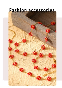 Detailed shot of golden floral beaded necklace and bracelet set on a textured beige surface