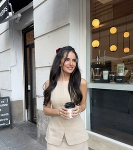 Chic beige sleeveless dress set with belt shown in a stylish outdoor street cafe setting