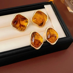 Detail view of vintage amber resin geometric earrings with gold trim in a jewelry box