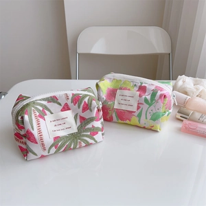 Detailed view of floral and leaf print jacquard cosmetic bags with zipper closure
