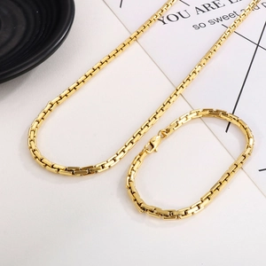 Detail of gold-plated rectangular box chain necklace and bracelet set with lobster clasp
