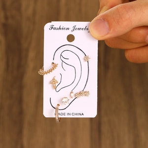 7-piece rose gold ear piercing set with stars, leaves and zircons on display card
