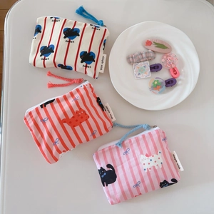 Detailed view of three striped cotton coin purses featuring cat and rabbit patterns