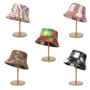 Close-up of plush tie-dye bucket hats in beige, pink, and brown plaid patterns