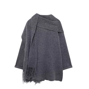Detail of soft dark grey knit sweater with matching tassel scarf and wool texture