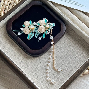 Barrette tulipe dorée élégante avec pétales vert menthe et pompon de perles sur support