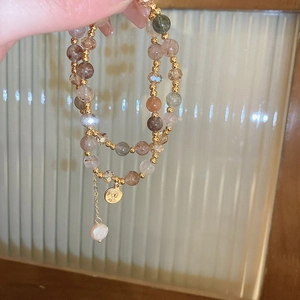 Detail of multilayer beaded bracelet with freshwater pearl and vintage gold coin pendant