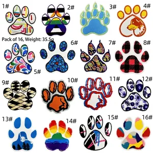 Grid view of sixteen colorful embroidered paw print patches with diverse artistic patterns