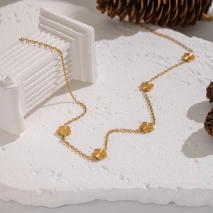 Elegant 18K gold plated stainless steel clover flower necklace on white marble background