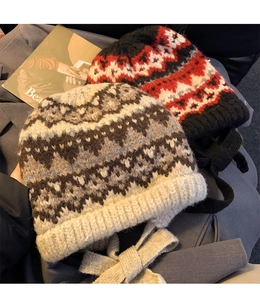 Close-up of retro Fair Isle knit beanies with colorful jacquard patterns and side ties