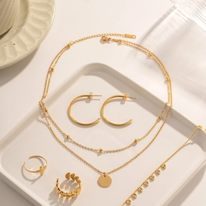 Close-up of 18K gold stainless steel jewelry set with double-layer necklace and rings