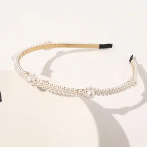 Detail view of champagne gold pearl headband with triple-row white pearls on display