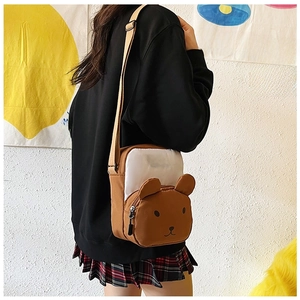 Detail view of cartoon bear crossbody bag with brown contrast and adjustable strap