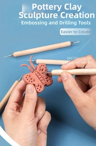 Wooden clay indentation tool creating detailed patterns on a clay butterfly figure