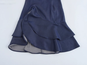 Vue détaillée de l'ourlet à volants et de la texture du denim de la minijupe bleue