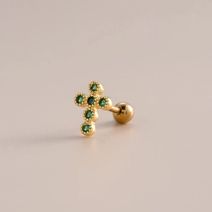 Macro shot of gold cross stud earring featuring green zircon stones and screw ball back