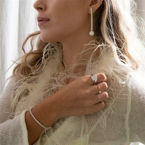 Elegant silver pearl drop earrings paired with luxury diamond jewelry on a model