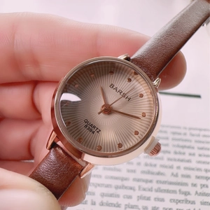 Close-up of vintage quartz watch with brown leather strap and rose gold case