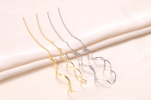 Detail of long spiral S925 silver threader earrings in gold and silver finishes