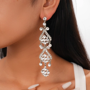 Close-up of luxury long tassel earrings with sparkling white crystals on model